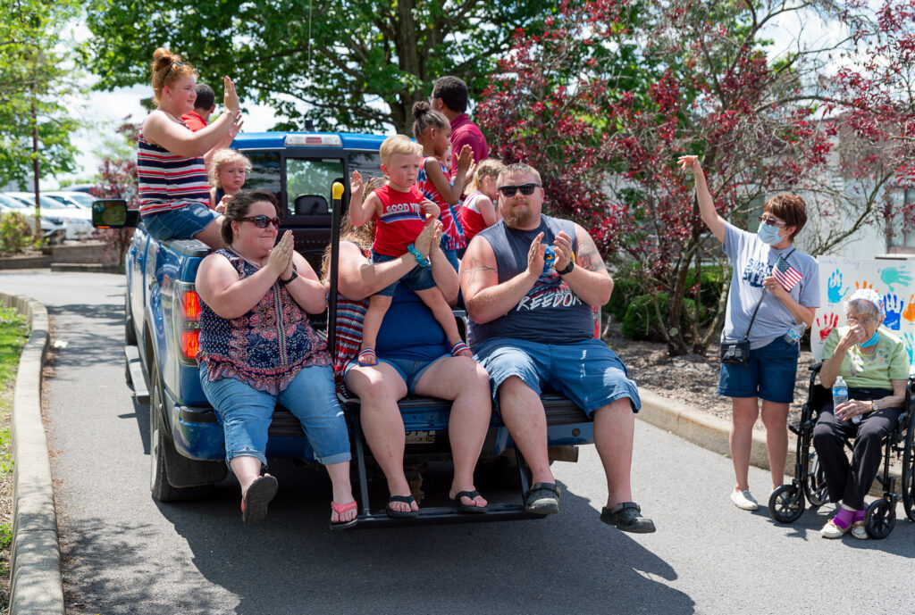 group on truckbed sings and claps as part of Sundale Memorial Day Parade