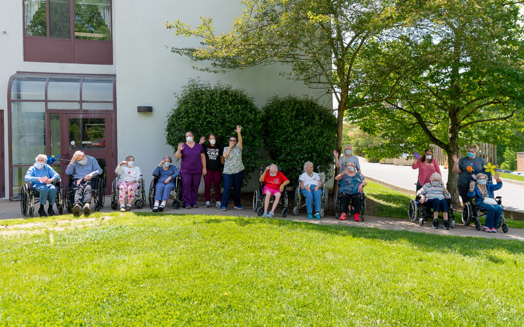 residents and staff wave to the Sundale Memorial Day parade