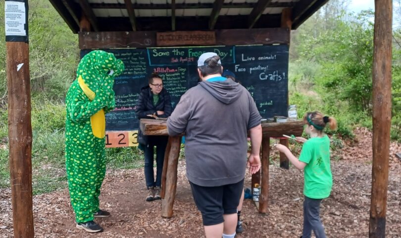 Community members participate in last year's Save The Frogs Day activities and meet Lloyd the Frog at Friends of Deckers Creek's Outdoor Learning Park. (Submitted photo)